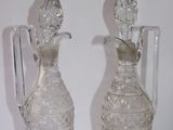 two clear glass vases sitting next to each other on a white surface