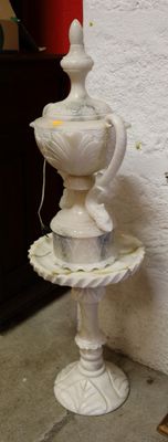 une fontaine blanche surmontée d'un oiseau
