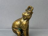 une image représentant une statue en or d'un éléphant sur fond gris
