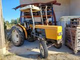 a yellow tractor that is parked in front of a building