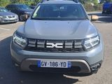 the front view of a grey dacia parked in a parking lot