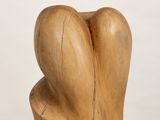 sculpture of a wooden heart on a white pedestal against a white background