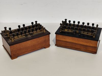 une paire de touches anciennes, en bois et noires, exposées sur un fond blanc