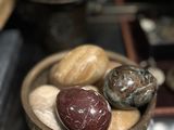 a bowl of stones on a table next to a tea kettle