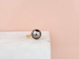 a black pearl ring sitting on top of a white marble block
