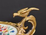 a gold plate with a bird on top of it