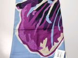 foulard à motifs floraux violets et bleus posé sur une nappe blanche