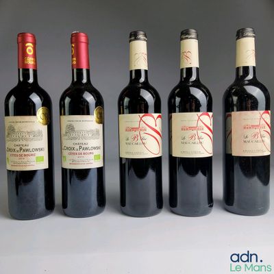 several bottles of wine are lined up in a row on a table