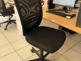 a black office chair sitting in front of a computer monitor