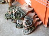 a pile of green and brown wheels on the ground next to an orange container
