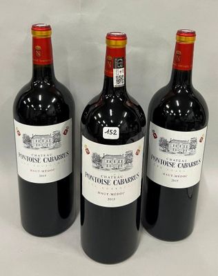 trois bouteilles de vin rouge sont alignées sur une surface blanche