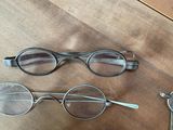 several pairs of glasses sitting on top of a wooden table