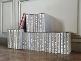 many books stacked on top of each other on the floor
