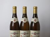 three bottles of wine sitting on top of a wooden table