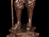 bronze statue of a man with a cane and a cane in his hand