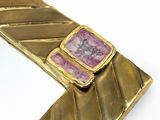 gold plated bracelet with a pink stone in the center