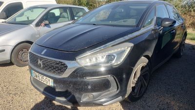 the front of a black car parked in a lot next to other cars