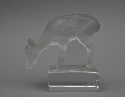 un animal en verre posé sur un socle
