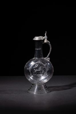 an old glass jug with a handle on a black background