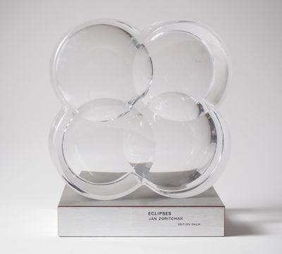 une image représentant une sculpture en verre transparent posée sur une surface blanche