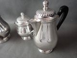a silver coffee pot and a silver tea pot on a table