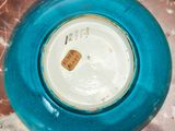 a close up of a blue vase with a tag on it