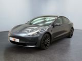une Tesla Model 3 grise garée dans un showroom