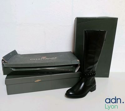 a pair of black boots and a box on a table