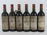 six bouteilles de vin sont alignées sur une surface blanche