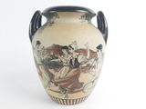a vase with a painting on it sitting on a table