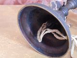 a silver trumpet sitting on top of a table next to a glass vase