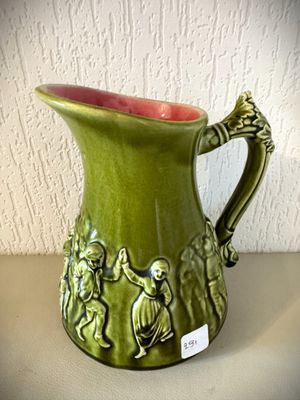 un vase vert sur lequel est représenté un groupe de personnes