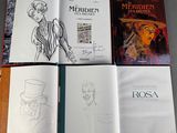 several books are lined up on a table with a drawing of a man in a top hat