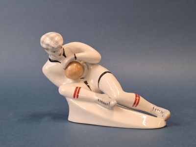 une figurine représentant un homme assis sur une planche de surf