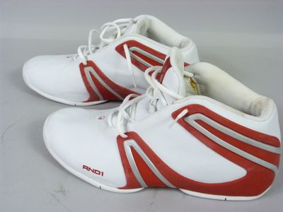 une paire de baskets blanches et rouges ornées de bandes rouges
