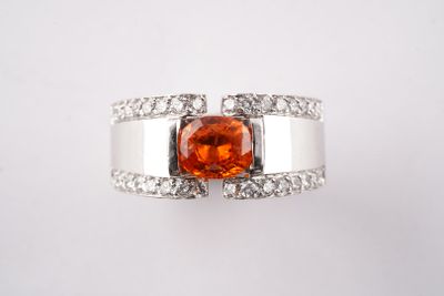 une bague avec une pierre orange entourée de diamants blancs