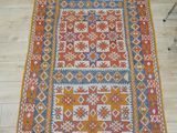 un tapis orange et bleu posé sur un parquet