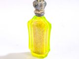une petite bouteille jaune surmontée d'une couronne