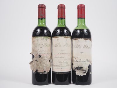 trois bouteilles de vin posées les unes à côté des autres sur une surface blanche