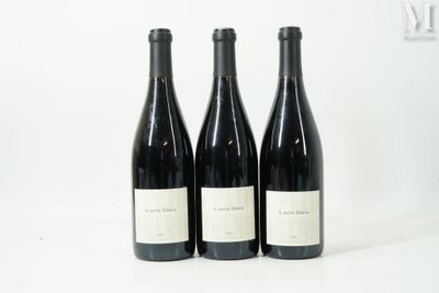 trois bouteilles de vin sont alignées sur une surface blanche