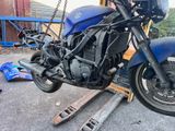 a blue motorcycle that is being worked on in the garage