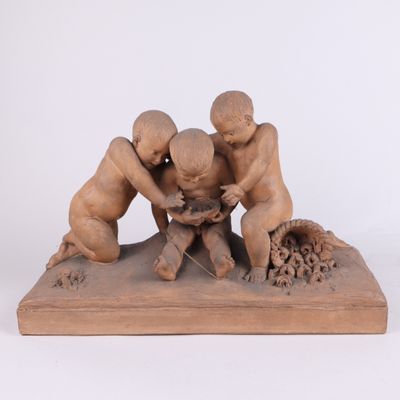 sculpture représentant trois enfants jouant avec un oiseau, posée sur un socle en bois