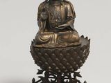 une statue en bronze représentant un Bouddha assis sur une fleur de lotus