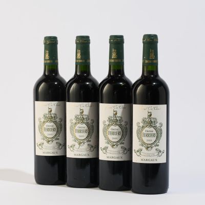 quatre bouteilles de vin sont alignées sur une surface blanche