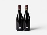 two bottles of red wine on a white background
