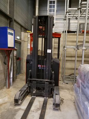 a forklift in a warehouse with a lot of boxes on the floor