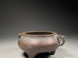 an old brown pot with a handle sitting on top of a table