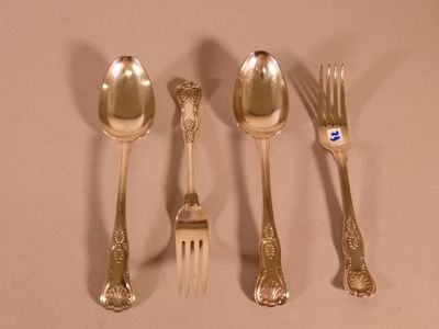 five silver spoons and a fork on a table