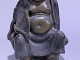 a small statue of a man sitting on a chair