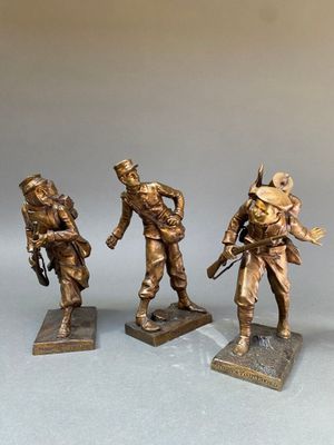 trois figurines en bronze représentant des soldats armés et coiffés de casques